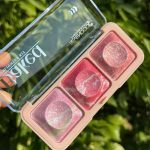 نمای نزدیک از درب شفاف پالت رژگونه شاین ۳ رنگ سون کول با نوشته‌های Baked Highlighter Kit و لوگوی برند SEVENCOOL در کنار رنگ‌های موجود